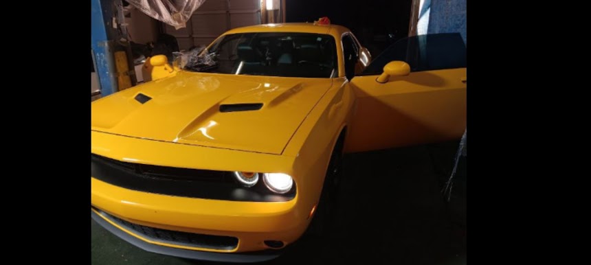 Yellow Dodge Challenger getting professional window tint at Affordable Tint Shop